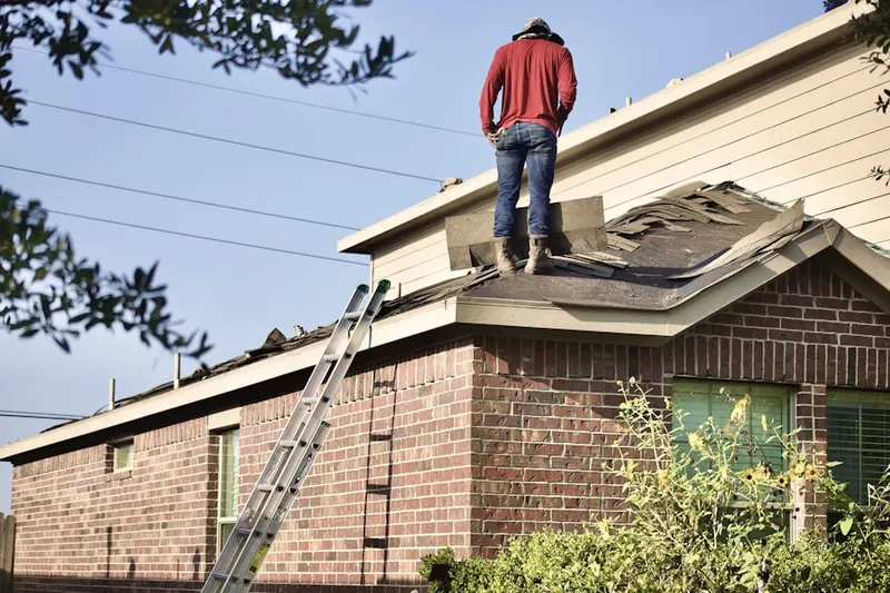 Professional roofer working on a residential roof in Highway City